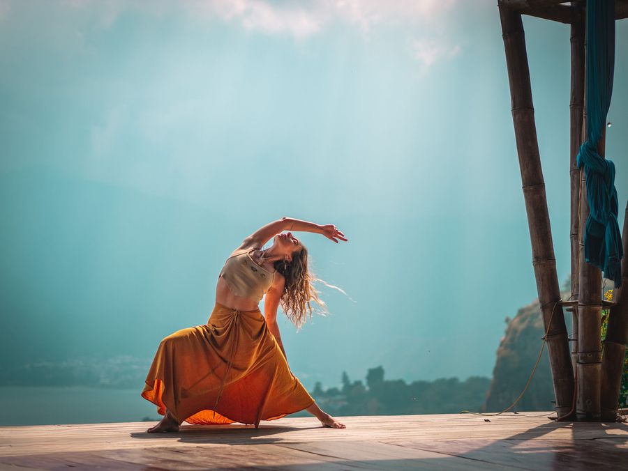 Chrystee dancing on a rooftop against a teal sky