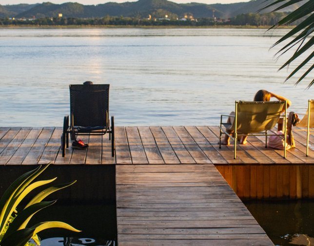 The lakeside deck at Samaya Wellness Lodge at sunset